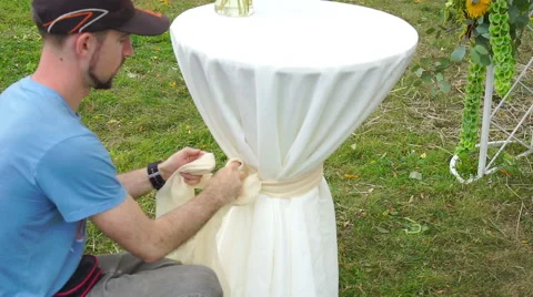 Florist man at work tying a bow on white table. Stock Footage 65923986