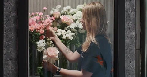 The florist puts on the gloves before work in her store Video stock 252144630
