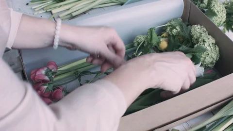 Florist puts inside cardboard box flowers Stock Footage 128138814