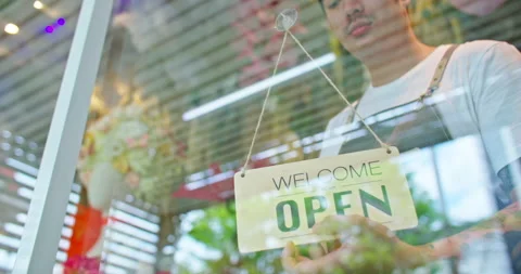 Florist shop owner turning a open sign board to opening store in morning. Video stock 233774792