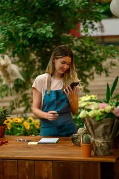 Florist talking with client on the smartphone and taking an order in a flower Stock Photos