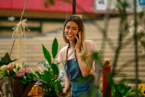 Florist talking with client on the smartphone and taking an order in a flower Stock Photos