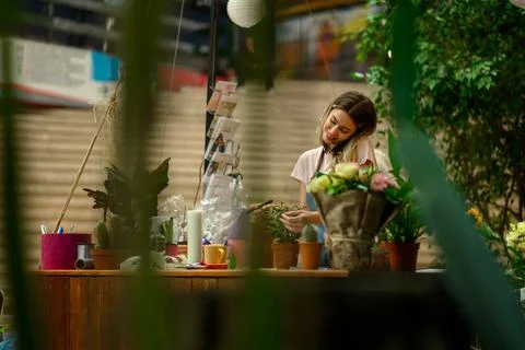 Florist talking with client on the smartphone and taking an order in a flower Stock Photos