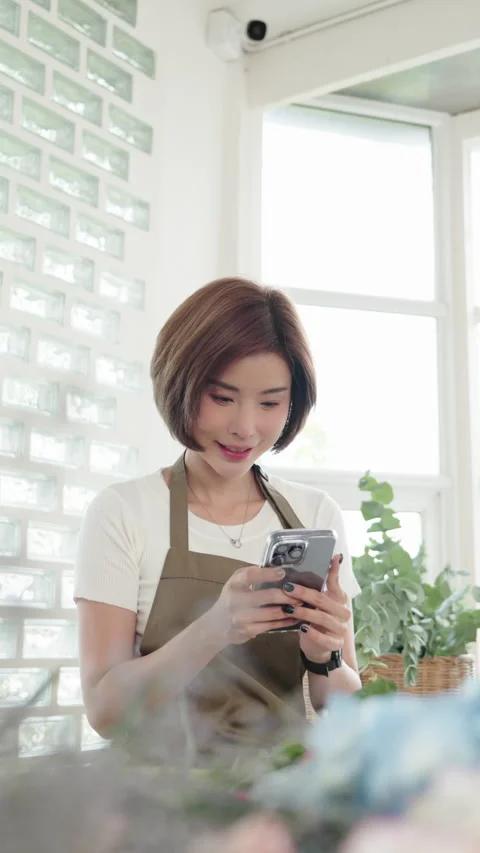 Florist using smartphone to capture her floral arrangements Stock Footage 272213131