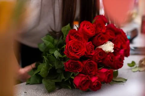 Florist at work. Close-up female hands cut roses Woman making a bouquet of re Stock Photos