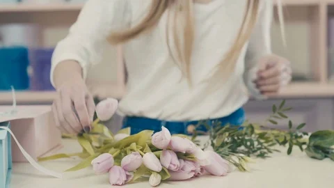 Florist at work at the ounter makes a bouquet of pink tulips Video stock 73506982