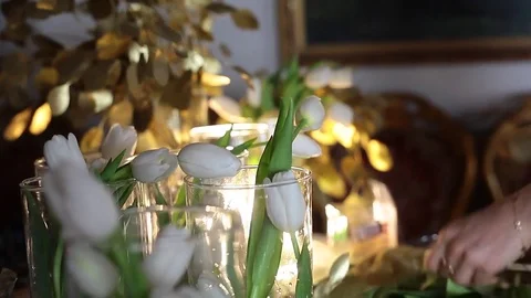 Florist at work. White Tulips in Clear Glass Vases, Golden Flowers on the Table Stock Footage 72906170