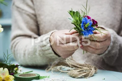 A florist working creating a small posy Stock Photos
