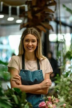 Florist working in flower shop while smiling and looking at a camera Stock Photos