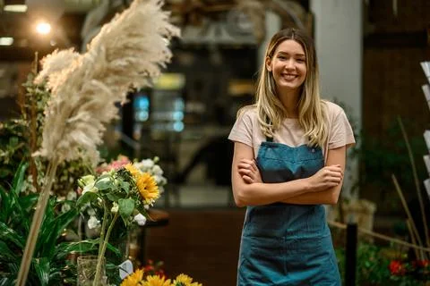 Florist working in flower shop while smiling and looking at a camera Stock Photos