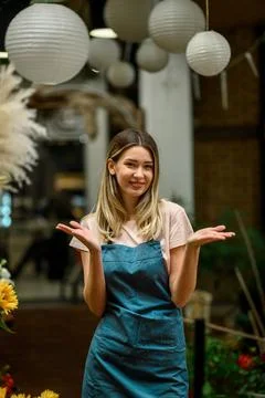 Florist working in flower shop while smiling and looking at a camera Stock Photos