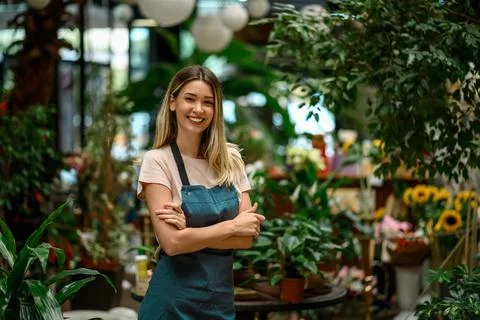 Florist working in flower shop while smiling and looking at a camera Stock Photos