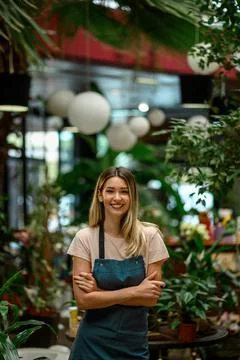 Florist working in flower shop while smiling and looking at a camera Stock Photos