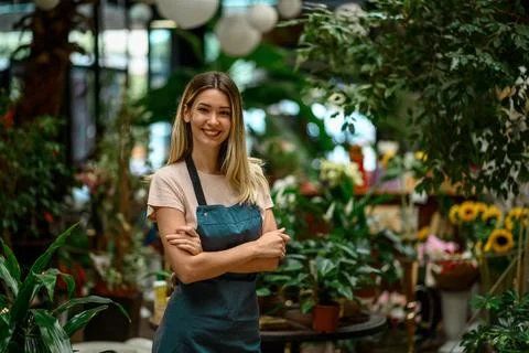 Florist working in flower shop while smiling and looking at a camera Stock Photos