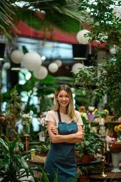 Florist working in flower shop while smiling and looking at a camera Stock Photos