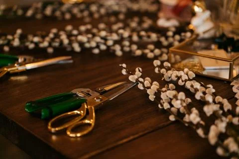 Florist workspace with tools and dried flowers on a wooden table, capturing the Stock Photos