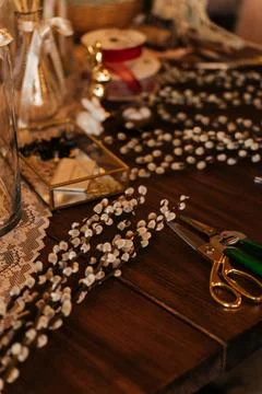 Florist workspace with tools and dried flowers on a wooden table, capturing the Stock Photos