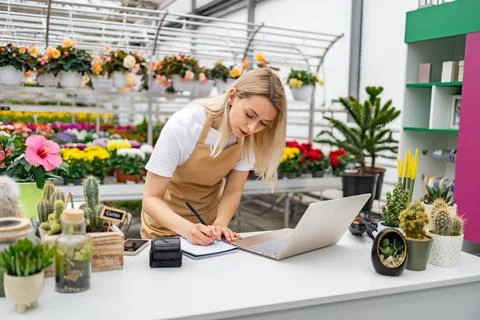 Florist Writing on Notebook at Sales Table Stock Photos
