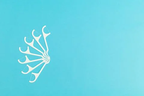 Floss with plastic handle on blue background Stock Photos