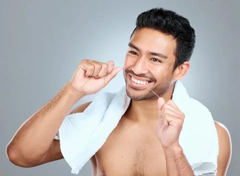 Flossing is a crucial step in avoiding cavities. a man using dental floss while Stock Photos