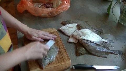 Flounder fish cleaning process on a cutting board at home. Stock Footage