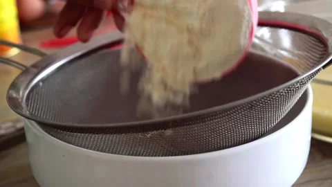 Flour and cocoa powder are being poured into the sieve Stock Footage