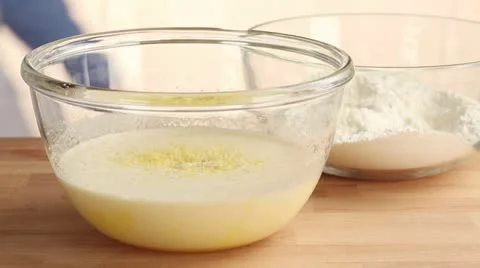Flour and melted butter being added to an egg and lemon mixture 스톡 동영상 24657152