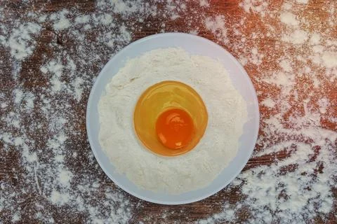 Flour and raw egg Stock Photos