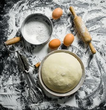 Flour background. The dough with a rolling pin, a sieve and a mixer. Stock Photos