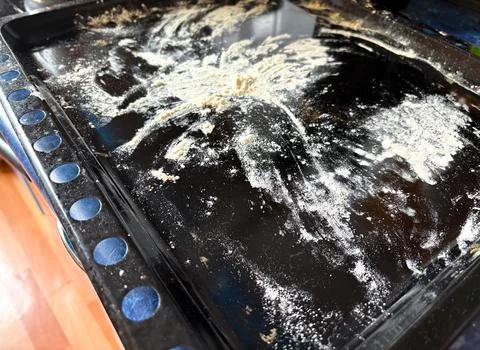 Flour on a baking sheet.Dirty baking tray. Stock Photos