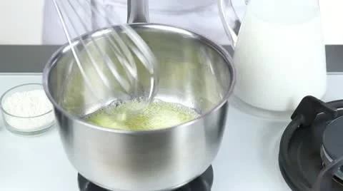Flour being added to melted butter and milk being added Stock Footage 24671204