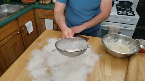 Flour being spread on table and dough being split in half kneading other half Video stock 159446082