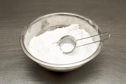 Flour in a bowl. sift. on the table in the kitchen Stock Photos