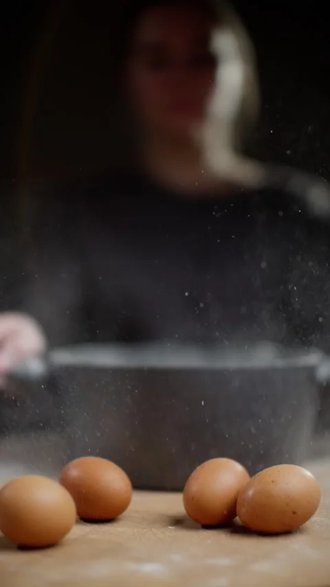 Flour dust scattering over dark gray pot, female chef sifting ingredients near Stock Footage 301640482