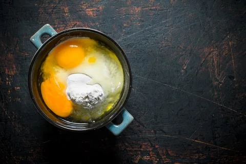 Flour with eggs in the pan. Stock Photos