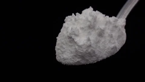 Flour extra class falling from the iron spoon, black background, slow motion Vidéo 74726058