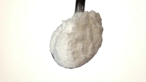Flour extra class falling from the iron spoon. White background. Slow motion Vidéo 75522159