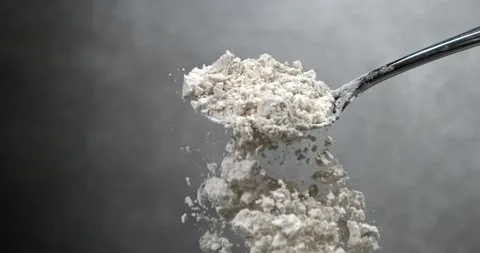 Flour falling from black spoon in super slow motion Video stock 344849193