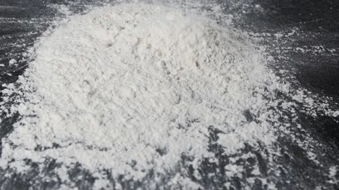 Flour falling on a black table in slow motion. Stock Footage 140247121