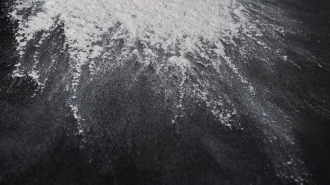 Flour is falling on a black table in slow motion. Stock Footage 140302143