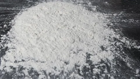 Flour is falling on the black table in slow motion. Stock Footage 140302147