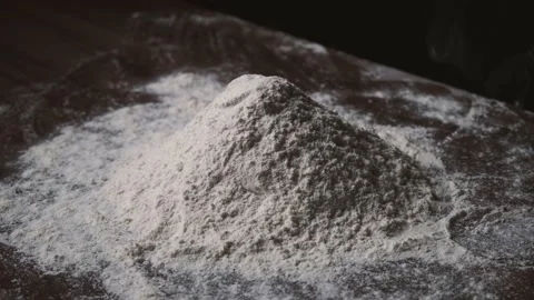 Flour is falling on the black table. Someone throwing flour on a dark background Stock Footage 131237609