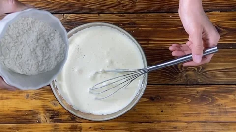 Flour falling down into bowl with dough Stock Footage 127616261