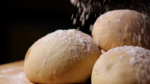 Flour falling on fresh bun in a bakery in slow motion Vídeo Stock 130955738