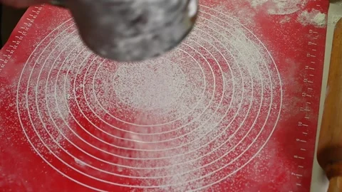 Flour falling from metal sifter onto red silicone baking mat, Stock Footage 334056511