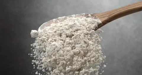 Flour falling from wooden spoon in super slow motion Video stock 342591319