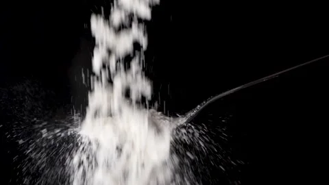 Flour falls in slow motion on a tablespoon isolated on black background Video stock 170433014