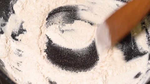 Flour is fried in a pan, stir with a wooden spatula Stock Footage 250267341