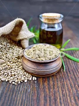 Flour hemp in bowl with oil on board Stock Photos