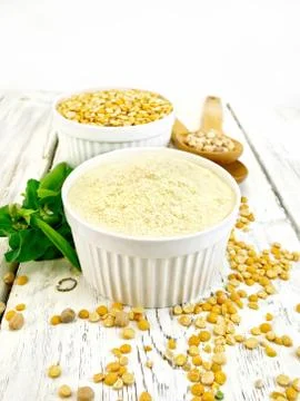Flour pea and split pease in white bowls on light board Stock Photos